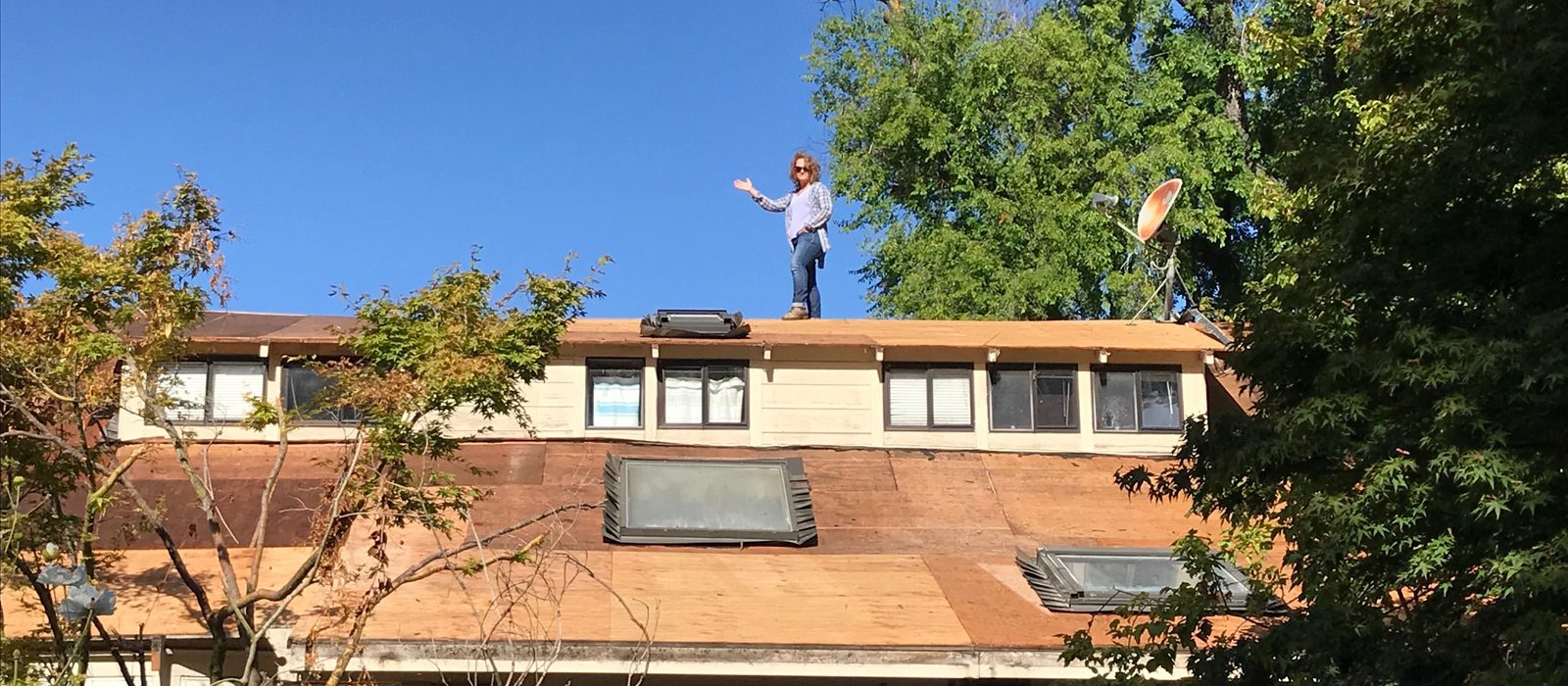 A person standing on the roof of a house